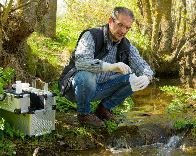 man taking sample of creek water