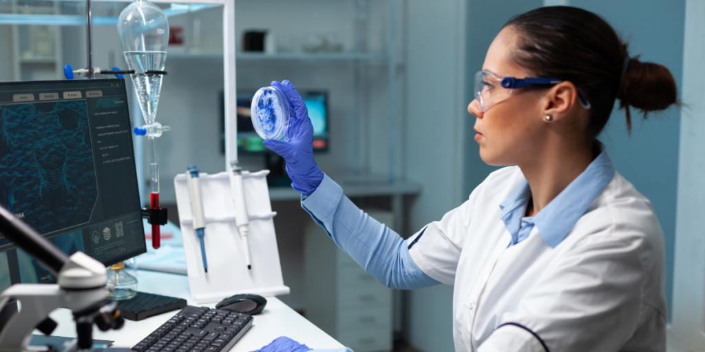 female lab worker analyzing something on a petri dish