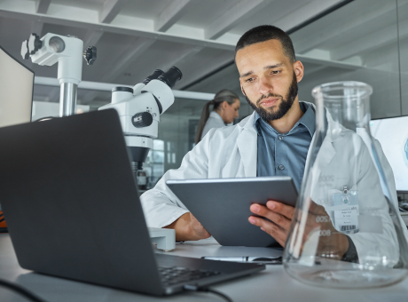 man using eln on tablet with laptop in front