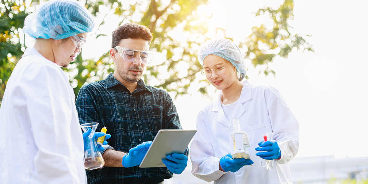 Scientists analyzing data with tablet during outside field research