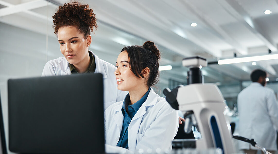 two female scientists looking at computers in lab