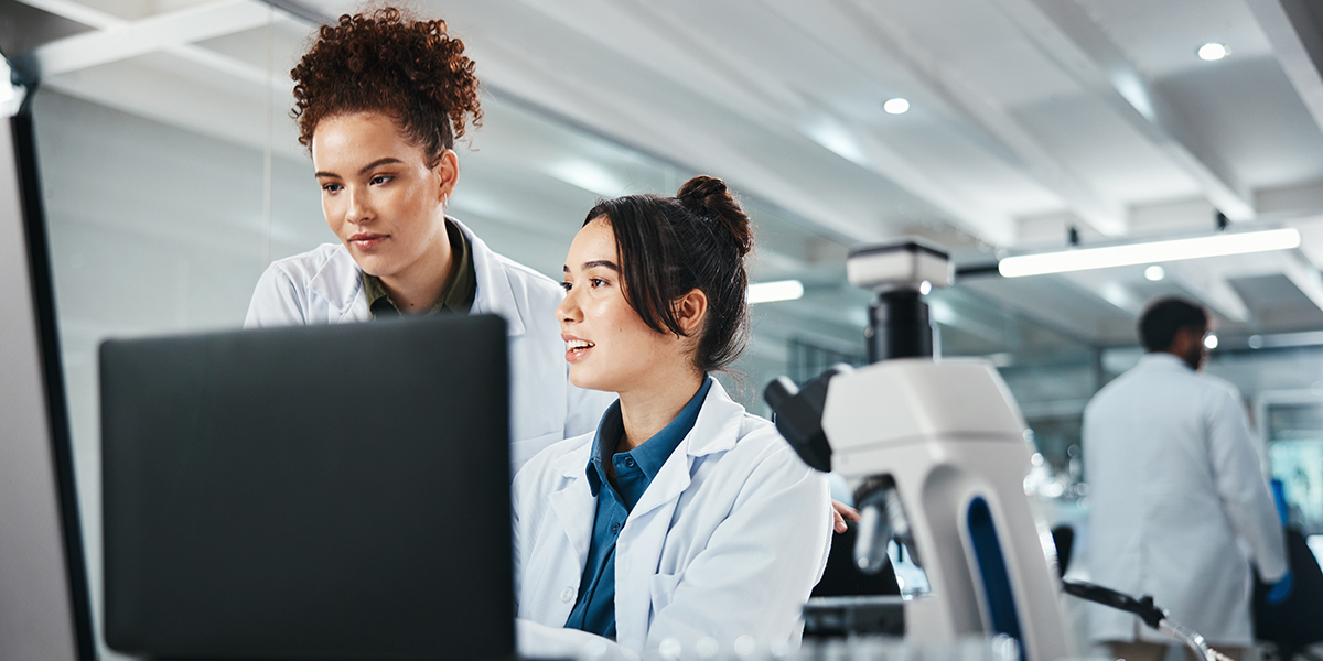 two female scientists looking at computers in lab