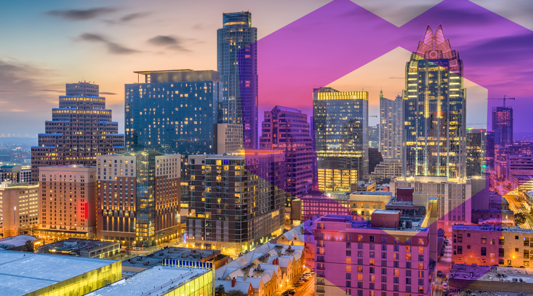 City skyline at dusk with illuminated buildings and pink-purple geometric overlay shapes in the sky.